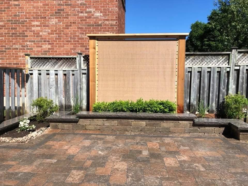 Completed paver patio with privacy screen and raised planter walls